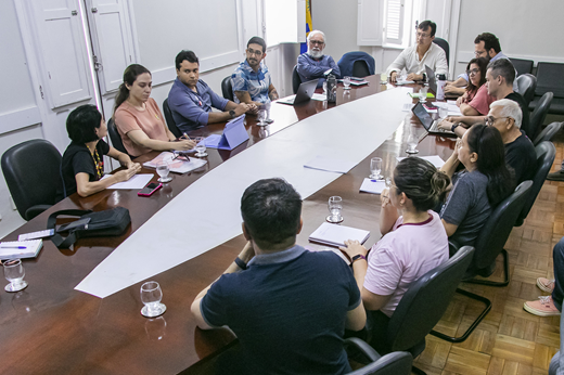 Imagem: Reunidos em uma mesa oval, estão o reitor Custódio Almeida e mais 12 pessoas, entre representantes do comando de greve dos TAEs, pró-reitores e assessores da Reitoria. (Foto: Álvaro Graça Jr./ UFC Informa)