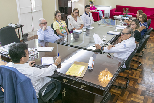 Imagem: Sentados à mesa, no Gabinete da Reitoria, o reitor Custódio Almeida recebe equipe do GEEON junto a outros representantes da administração superior. (Foto: Álvaro Graça Jr./ UFC Informa)