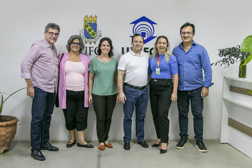 Imagem: De pé, da esquerda para a direita: Prof. Barros Neto (PROINTER), Profª Bernadete Porto (PREX), Luzia Bastos (Instituto Myra Eliane), Igor Queiroz (presidente do Instituto Myra Eliane), Euzene Matos (diretora do CEI) e Prof. Custódio Almeida (reitor). (Foto: Álvaro Graça Jr./ UFC Informa)