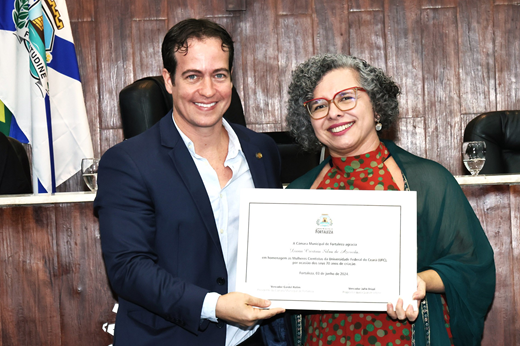 Imagem: O vereador Júlio Brizzi posa com a vice-reitora da UFC, Profª Diana Azevedo. Eles seguram o certificado entregue a ela pela Câmara Municipal. (Foto: André Lima/CMFOR)