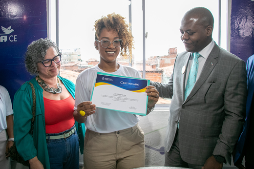 Imagem: Ladeada pela vice-reitora Diana Azevedo e pelo ministro Silvio Almeida, a concludente Talita Silva segura seu certificado. (Foto: Álvaro Graça Jr./ UFC Informa).