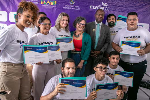 Imagem: Nove alunos do estação Favela posam com a vice-reitora Diana Azevedo e o ministro Silvio Almeida; eles seguram certificados. (Foto: Álvaro Graça Jr./ UFC Informa)