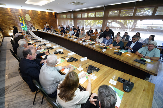 Imagem: Participantes da reunião sentados à mesa no Salão Oval do Palácio da Abolição. Ao centro, o governador Elmano de Freitas. (Foto: ASCOM FIEC/ Divulgação)