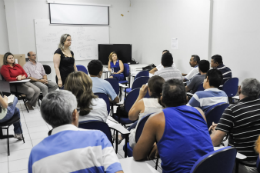 Imagem: servidores sentados em uma sala para acompanhar a reunião