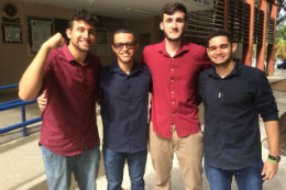 Quatro jovens em pé, abraçados, posando para foto