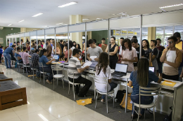 Pessoas em fila sendo atendidas por servidores na Prograd