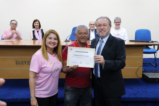 Imagem: Foto do servidor Francisco Almeida do Nascimento ladeado pelo reitor Cândido Albuquerque e pela pró-reitora-adjunta Telma Araújo