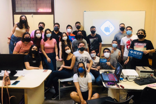 Imagem: grupo de estudantes posa para a câmera em sala de aula