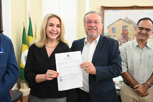 Imagem: Foto da nova pró-reitora de Assuntos Estudantis da UFC, Profª Nadja Dutra, recebendo o termo de posse das mãos do reitor Cândido Albuquerque