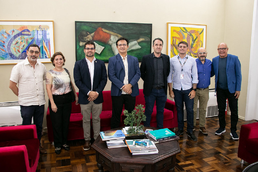 Imagem: pessoas em pé posam para a foto no gabinete do reitor