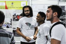 Imagem: foto de três jovens observando um banner