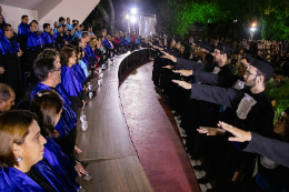 Representantes de cada curso se enfileiram perante a mesa diretora e fazem o juramento da formatura