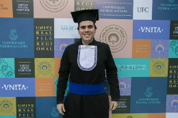 Foto do estudante Marco Chrystian, bacharel em Economia Ecológica pela UFC, trajando beca de formatura