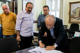 Foto do reitor Cândido Albuquerque assinando o convênio