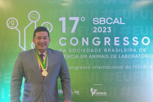 Imagem: Pesquisador Wesley Ribeiro em frente ao banner do 17º Congresso da Sociedade Brasileira de Ciência em Animais de Laboratórios (Foto: Chico Gomes)