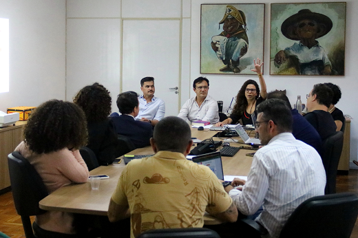 Imagem: pessoas em volta de uma mesa em reunião