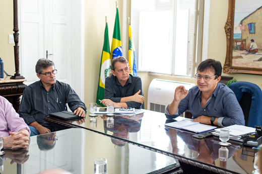 Imagem: pessoas em volta de uma mesa em reunião